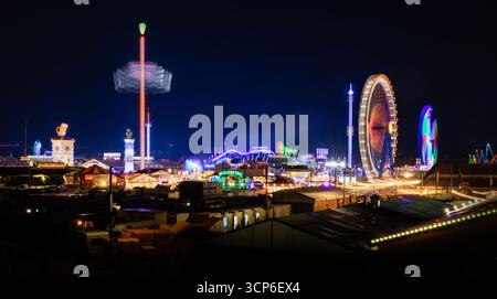 Panorama dell'Oktoberfest di Monaco di notte - festival popolare famoso in tutto il mondo con luci colorate, giostre e tende accoglienti nella metropoli bavarese - Germ Foto Stock