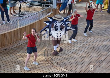 Venezia. Italia - 24 settembre 2025: La mascotte del Carnevale, Fun Ship Freddy, balla energicamente con il team di intrattenimento sul ponte del lido durante una liv Foto Stock