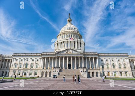 Edificio del Campidoglio degli Stati Uniti Washington DC USA | WASHINGTON DC — L'edificio del Campidoglio degli Stati Uniti, un famoso punto di riferimento a Washington D.C., è raffigurato sotto un cielo blu brillante con nuvole sparse. Questa struttura iconica funge da luogo di incontro per il Congresso degli Stati Uniti, composto dal Senato e dalla Camera dei Rappresentanti. La sua cupola distintiva è un simbolo della democrazia americana e dell'orgoglio nazionale, mostrando elementi di design neoclassico che riflettono la sua importanza storica e grandiosità. Il Campidoglio degli Stati Uniti si trova all'estremità orientale della National Mall, un vasto parco pubblico e cerimoni Foto Stock