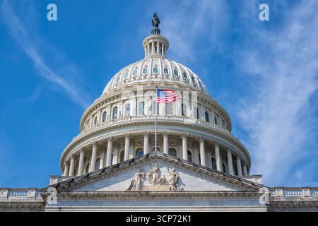 US Capitol Building Dome Washington DC // WASHINGTON DC - la cupola del Campidoglio DEGLI Stati Uniti è mostrata contro un cielo blu con nuvole mostruose. La cupola è sormontata dalla Statua della libertà e presenta elementi architettonici classici, tra cui colonne e finestre ad arco. Una bandiera americana vola da un palo sull'esterno dell'edificio. Il Campidoglio funge da luogo di incontro del Congresso degli Stati Uniti ed è un importante punto di riferimento nella capitale della nazione. La costruzione dell'attuale cupola è stata completata nel 1863 ed è un simbolo della democrazia americana. Foto Stock