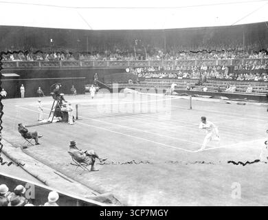 Coppa Davis a Wimbledon: Australia V GT. Gran Bretagna -- Una visione generale della partita tra Crawford (Australia). E Austin (Gran Bretagna). Quando Crawford ha vinto 4-6; 6-2; 6-2; 6-3. Jack Crawford, Joreground, gioca sul campo centrale di Wimbledon durante una partita di Coppa Davis contro la Gran Bretagna nel 1933. 14 agosto 1933. Foto Stock