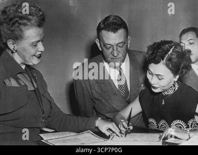 Diventa cittadina americana -- la moglie cinese del maggiore generale Claire Chennault firma i suoi documenti di naturalizzazione dopo essere stata ammessa alla cittadinanza americana oggi al tribunale distrettuale degli Stati Uniti. Da sinistra a destra: Sig.ra Helen T. Nelson, vicesegretario della Corte; Chennault, Comandante delle famose "Tigri volanti" in tempo di guerra; sig.ra Chennault, e un osservatore non identificato. 14 novembre 1950. (Foto di AP Wirephoto) Foto Stock