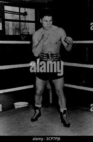 Don Cockell in allenamento nella scuderia Solomons -- campione britannico ed europeo dei pesi mediomassimi Don Cockell guarda ogni centimetro il combattente aggressivo che ha dimostrato di essere mentre si allena a Jack Solomons **** street (Londra) Gymnasium. Cockell è considerato un avversario di Joey Maxim (USA) in un concorso per il titolo mondiale. Cockell indossa la sua preziosa cintura Lonedale. Campione britannico ed europeo di pugilato leggero e pesante, Don Cockell, considerato come un avversario per il detentore del titolo mondiale, Joey Maxim, dell'America. 6 aprile 1951. (Foto di Fox Photos) Foto Stock