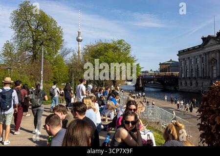 Berlino, Germania, 5 maggio 2025, vivace scena di strada lungo il fiume Sprea a Berlino con una grande folla di persone che si rilassano e camminano in una giornata di sole. Il Foto Stock