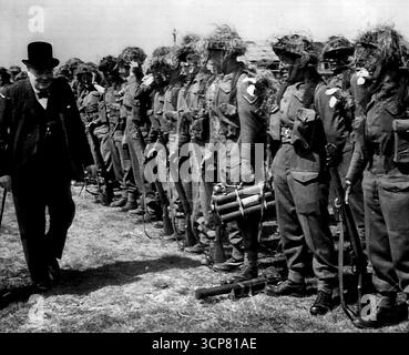 Churchill ispeziona le truppe mimetizzate - il primo ministro Winston Churchill ispeziona le truppe che indossano caschi d'acciaio mimetici durante un tour di ispezione delle truppe d'invasione in Gran Bretagna il 12 maggio. 12 maggio 1944. (Foto di AP Wirephoto). Foto Stock