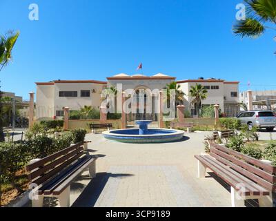 Bellissimo edificio antico e palme sotto un cielo blu a Dakhla, nel Sahara Occidentale Foto Stock