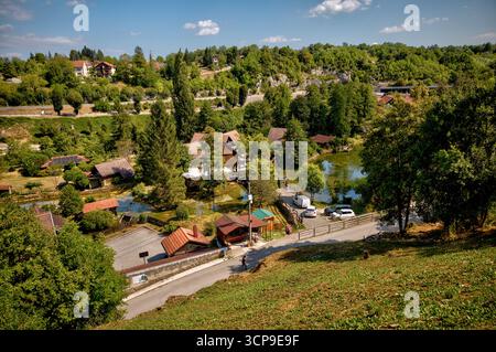 Tradizionali case in legno e mulini ad acqua fiancheggiano i fiumi e le cascate di Rastoke, un villaggio storico conosciuto come la "piccola Plitvice". Foto Stock