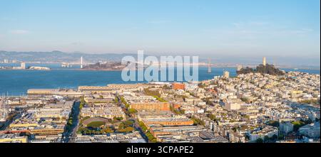 Vista aerea della città che rivela l'iconica Coit Tower e l'isola di Alcatraz sotto un cielo luminoso, San Francisco, California, Stati Uniti. Foto Stock