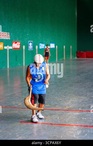Un pelotari filippino con il cesta che gioca a jai alai, un tempo sport basco molto popolare nelle Filippine, in un fronton locale a Manila Foto Stock