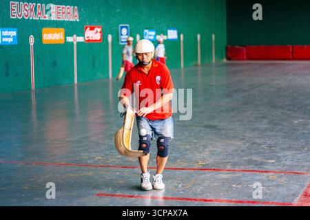 Un pelotari filippino con il cesta che gioca a jai alai, un tempo sport basco molto popolare nelle Filippine, in un fronton locale a Manila Foto Stock