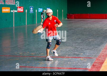 Un pelotari filippino con il cesta che gioca a jai alai, un tempo sport basco molto popolare nelle Filippine, in un fronton locale a Manila Foto Stock