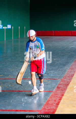 Pelotari filippino che gioca a jai alai, uno sport basco un tempo molto popolare nelle Filippine, in un fronton locale a Manila Foto Stock