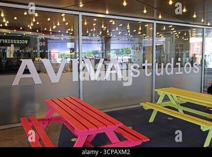 Vista esterna degli Aviva Studios, sede della Factory International, che mostra un moderno luogo culturale e un'area con posti a sedere pubblici nel centro di Manchester. Foto Stock