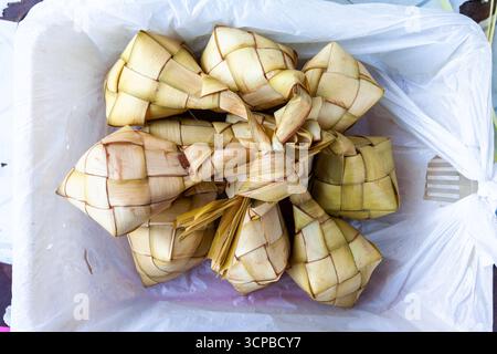 Puso, o riso appeso, un piatto tradizionale Cebuano simile al ketupat, dove il riso viene cotto all'interno di un contenitore di foglie di cocco intrecciato a Cebu, Filippine Foto Stock