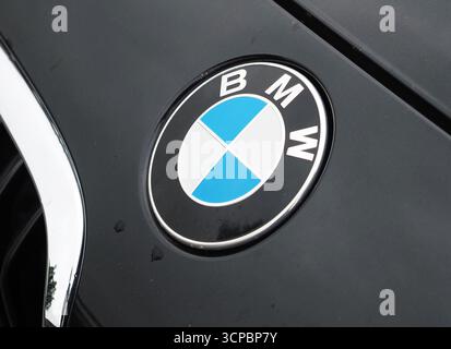 Vilshofen sul Danubio, Germania. 25 settembre 2025. Un'immagine ravvicinata della classica BMW Roundel. Il logo circolare blu, bianco e nero si trova su una superficie scura e lucida per auto. Il fregio è pulito e ben definito, e il rivestimento cromato circostante riflette una fonte di luce sfocata. Alcune gocce d'acqua sono visibili sulla superficie dell'auto accanto al logo (foto di Igor Golovniov/SOPA Images/Sipa USA) credito: SIPA USA/Alamy Live News Foto Stock