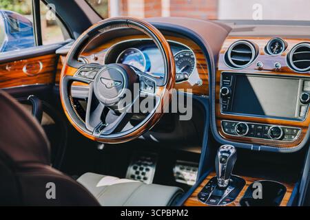 Vilnius, Lituania - 2025-09-09 - interno di Bentley Bentayga con volante in legno e dettagli in pelle blu Foto Stock