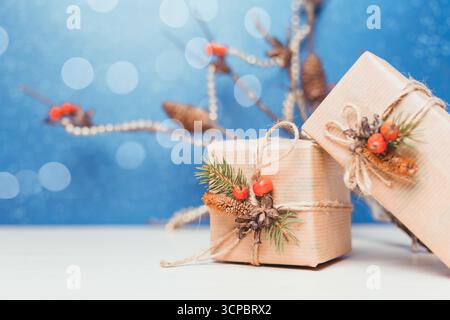 Scatole regalo per le feste decorate con elementi naturali su sfondo blu brillante Foto Stock
