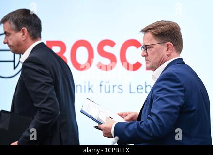 Gerlingen, Germania. 25 settembre 2025. Stefan Grosch (r), membro del Consiglio di amministrazione e direttore del lavoro della Robert Bosch GmbH, lascia la sala conferenze dopo una conferenza stampa sui tagli al lavoro. Sulla sinistra c'è Thomas Pauer, presidente della divisione Power Solutions di Robert Bosch GmbH. Crediti: Bernd Weißbrod/dpa/Alamy Live News Foto Stock