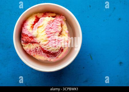 Pallina da gelato in tazza di carta su un tavolo vintage blu, spazio per testo Foto Stock