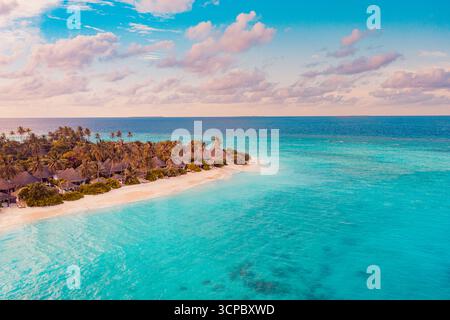 Fantastico tramonto aereo isola delle Maldive destinazione di viaggio di lusso mare azzurro baia palme colorate nuvole di cielo droni vista. Una vacanza panoramica perfetta Foto Stock