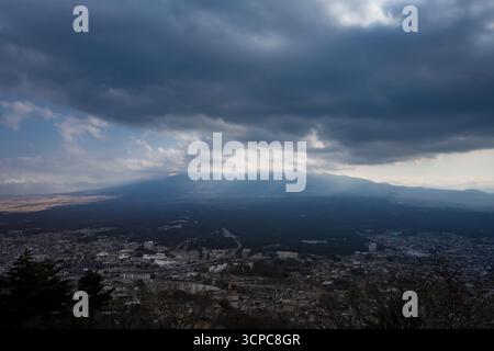 Primo piano di una cima innevata del Monte Fuji, circondata da nuvole. Vista da Fujikawaguchiko, Giappone. Foto Stock