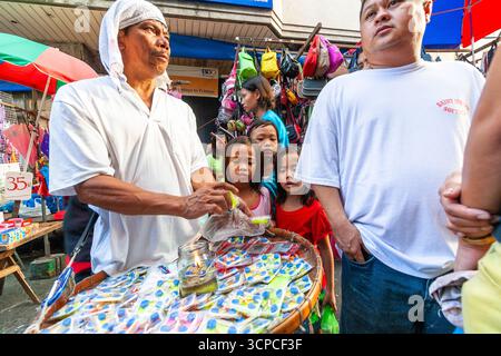 Venditori ambulanti in un affollato mercato di strada durante le vacanze natalizie nel centro di Manila, Filippine Foto Stock