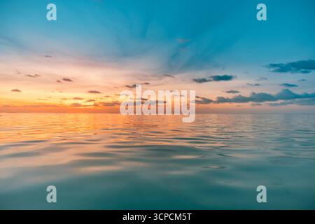 Splendido tramonto sul mare con vivaci riflessi del cielo che creano una tranquilla scena naturale, con una vista dell'orizzonte serena ideale come rilassante sfondo meditativo Foto Stock