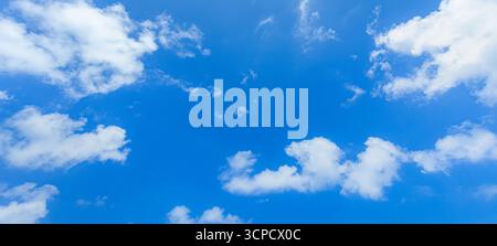 Cielo azzurro felice nuvole bianche e soffici che ispirano un'atmosfera tranquilla, luce naturale, serena e luminosa, atmosfera rilassante, sfondo tranquillo Foto Stock