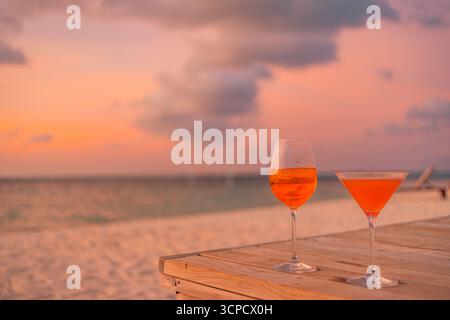 Romantico tramonto cielo, cocktail sulla spiaggia, vista oceano, due mani che alzano gli occhiali aperol, atmosfera estiva tropicale, cielo caldo, vivace scenario di viaggio all'orizzonte marino Foto Stock