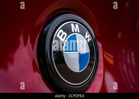 Primo piano del logo BMW sulla BMW X4 rossa con dettagli riflettenti Foto Stock