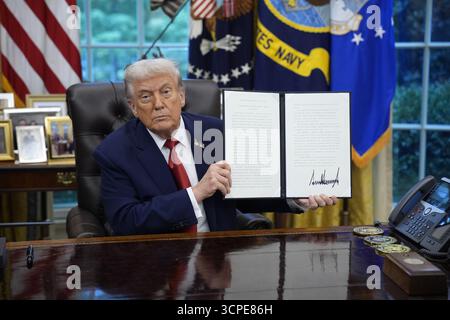 Il presidente degli Stati Uniti Donald J Trump espone uno dei diversi ordini esecutivi che ha firmato nell'Ufficio ovale della Casa Bianca a Washington, DC, USA, il 25 settembre 2025.credito: Yuri Gripas/Pool via CNP/MediaPunch Foto Stock
