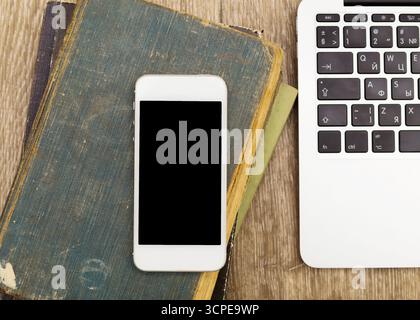 Tecnologia moderna e letteratura classica si combinano su una scrivania in legno Foto Stock