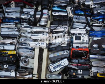 TOKYO, GIAPPONE - 24 luglio 2025: Vassoi pieni di vecchio digitale fuori da un negozio di seconda mano ad Akihabara Foto Stock