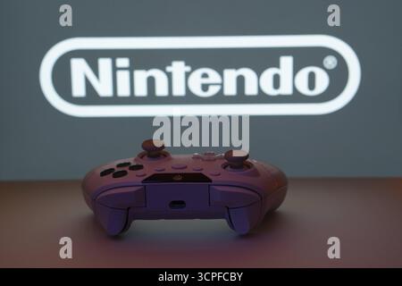 Dhaka, Bangladesh- 15 luglio 2025: Primo piano di un gamepad con nintendo sullo schermo sullo sfondo Foto Stock