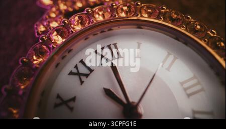 Primo piano dell'orologio decorativo con numeri romani e cornice gioiellata decorata che mostra l'ora esatta. Design elegante che simboleggia eleganza, lusso, puntualità, tradizione. Concetto simbolico di misurazione del tempo Foto Stock
