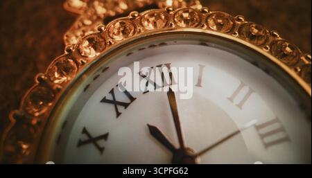 Primo piano dell'orologio decorativo con numeri romani e cornice gioiellata decorata che mostra l'ora esatta. Design elegante che simboleggia eleganza, lusso e tradizione. Concetto simbolico di misurazione del tempo. Temporizzato. Foto Stock