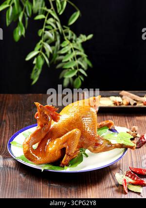 Pollo intero glassato in stile cinese su tavolo in legno rustico Foto Stock