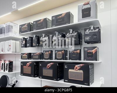 Poznan, Polonia - 20 settembre 2025: Vari articoli audio Marshall, casse e cuffie confezionate, sono disposti in modo ordinato sugli scaffali, invitanti Foto Stock