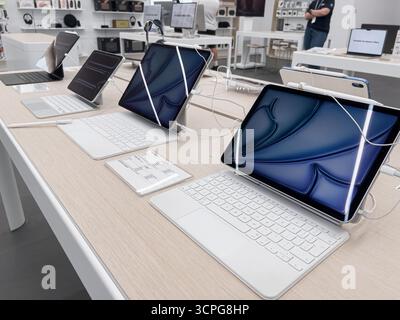 Poznan, Polonia - 20 settembre 2025: I tablet Apple iPad Pro, le tastiere magiche e le matite Apple sono presentati in modo prominente in un retai elettronico pulito Foto Stock