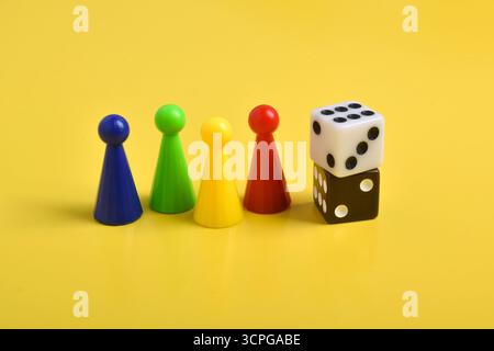 Coloratissime chip di gioco e due dadi isolati su uno sfondo giallo Foto Stock