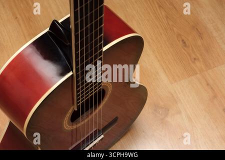 Vista dall'alto di una bellissima chitarra acustica. Sfoggiano dettagli complessi e calde tonalità di legno. Messa a fuoco selettiva Foto Stock