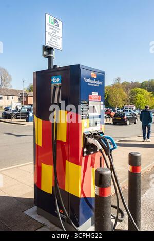 Stazione di ricarica per veicoli elettrici in un parcheggio a Morpeth Northumberland, circondato da auto e alberi in una giornata di sole Foto Stock