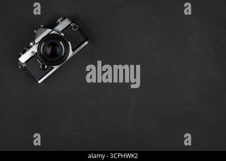 Fotocamera fotografica retrò Vista dall'alto Flat su sfondo nero testurizzato con spazio di copia Foto Stock