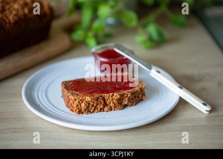 fetta friabile di noci o semi di pane, ricoperta di marmellata di fragole dolci o lamponi. Foto Stock