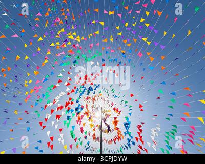Bandiere colorate e aeroplani creano un'atmosfera vivace contro un cielo azzurro. La scena cattura un'atmosfera festosa, ideale per feste ed ev Foto Stock