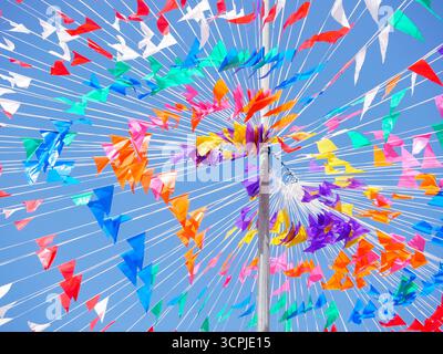 Bandiere colorate e aeroplani creano un'atmosfera vivace contro un cielo azzurro. La scena cattura un'atmosfera festosa, ideale per feste ed ev Foto Stock