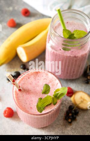 Frullato misto rinfrescante di frutti di bosco e banane con guarnizione alla menta. Foto Stock