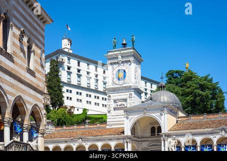Torre dell'Orologio a Udine, Italia. Parte della Loggia di San Giovanni in Piazza della Libertà. Castello di Udine sullo sfondo. Foto Stock