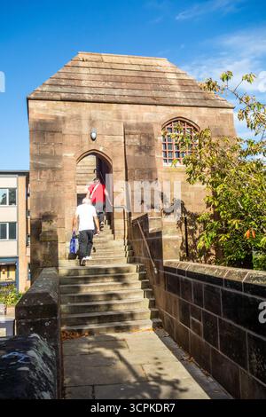 Persone che camminano per le storiche mura di Chester City, Cheshire, camminando fino a una delle sue torri Foto Stock