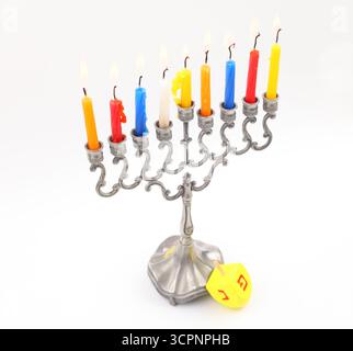 Le candele di Hanukkah bruciano di dreidel, isolate sul bianco Foto Stock
